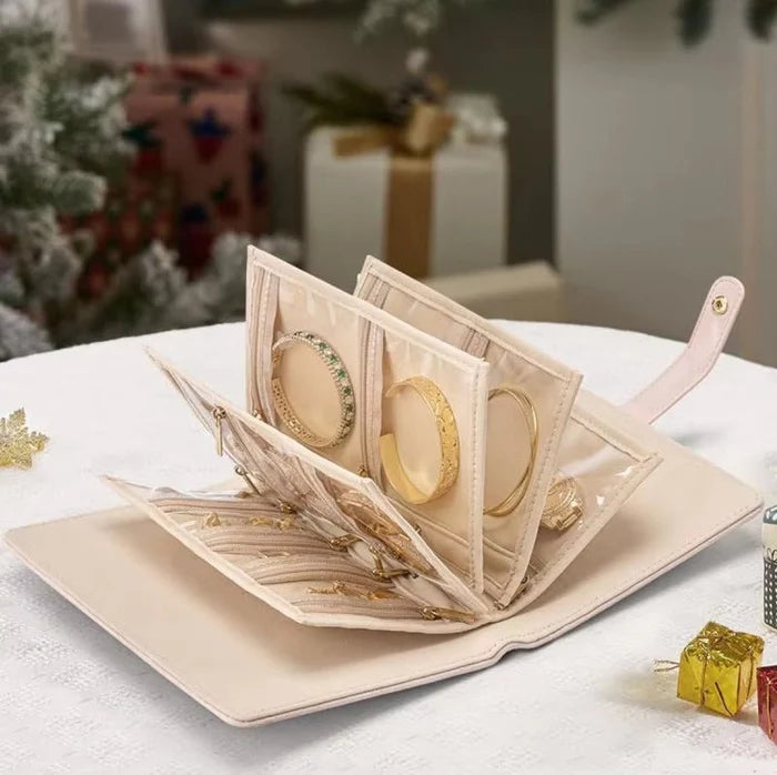 Beige jewelry display box with gold rings on a white surface.